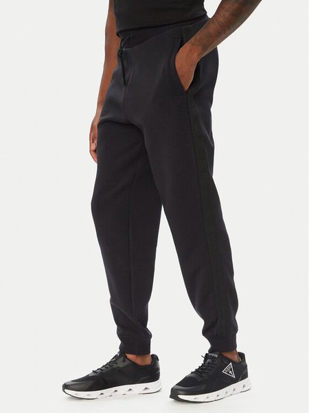 Guess Spodnie dresowe Z6YB13 K4965 Czarny Regular Fit. Czarne spodnie dresowe męskie Guess, z aplikacjami, z dresówki. Za 394.99 zł.