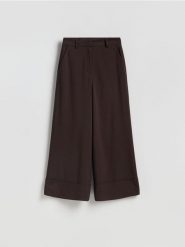 Luźne spodnie - ciemnobrązowy. Brązowe spodnie materiałowe damskie Reserved, bez wzorów, z tkaniny. Za 139.99 zł.