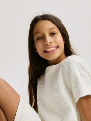 Tweedowa sukienka z cekinami - złamana biel. Sukienki dziewczęce Reserved, bez wzorów, z dzianiny, bez ramiączek. Za 89.99 zł.