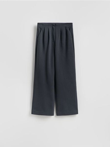 Spodnie z zakładkami - ciemnoszary. Szare spodnie materiałowe damskie Reserved, bez wzorów, z bawełny. W wyprzedaży za 49.99 zł.