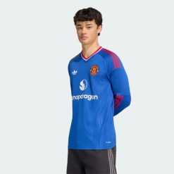 Koszulka wyjazdowa z długim rękawem Manchester United 26/27. Niebieskie koszulki męskie z długim rękawem Adidas, l, z dzianiny, bez ramiączek, do piłki nożnej, climacool (adidas). Za 441.50 zł.