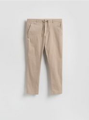 Spodnie joggery - beżowy. Brązowe spodnie materiałowe męskie Reserved, bez wzorów, z bawełny. Za 149.99 zł.