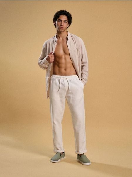 Spodnie chino jogger - kremowy. Białe spodnie materiałowe męskie Sinsay, bez wzorów. Za 69.99 zł.