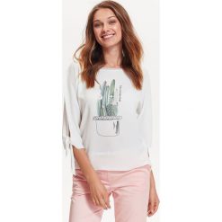 BLUZKA Z ŁĄCZONYCH MATERIAŁÓW, Z ROZCIĘCIAMI NA RĘKAWACH, Z NADRUKIEM. Białe bluzki damskie TOP SECRET, bez wzorów, z dzianiny, eleganckie, bez kołnierzyka, bez ramiączek. W wyprzedaży za 29.99 zł.