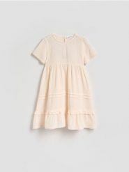 Muślinowa sukienka - kremowy. Białe sukienki dziewczęce Reserved, bez wzorów, z bawełny, bez ramiączek. Za 79.99 zł.