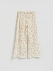 Ażurowe spodnie - kremowy. Białe spodnie materiałowe damskie Reserved, w ażurowe wzory, z bawełny. Za 199.99 zł.