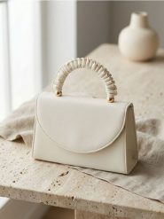 Kopertówka z ozdobnym uchwytem i łańcuszkiem - biały. Białe torebki wieczorowe Sinsay, bez wzorów, bez kołnierzyka, bez ramiączek. Za 39.99 zł.