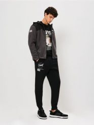 Spodnie tapered fit NASA - czarny. Czarne spodnie materiałowe męskie Sinsay, bez wzorów. Za 59.99 zł.
