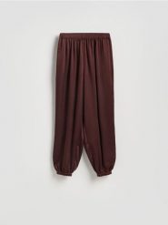 Spodnie balloon - mahoniowy. Brązowe spodnie materiałowe damskie Reserved, bez wzorów, z tkaniny. Za 119.99 zł.