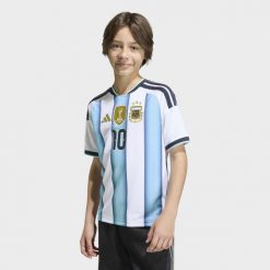 Dziecięca koszulka domowa Argentyna 26 Messi. Białe bluzki sportowe damskie Adidas, m, z dzianiny, bez kołnierzyka, bez ramiączek. Za 409.00 zł.