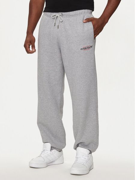 Guess Jeans Spodnie dresowe M4YB18 K9V31 Szary Regular Fit. Szare spodnie dresowe męskie Guess Jeans, z aplikacjami, z bawełny. Za 229.99 zł.