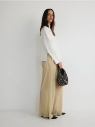 Spodnie wide leg - kremowy. Białe spodnie materiałowe damskie Reserved, bez wzorów, z dzianiny. W wyprzedaży za 49.99 zł.