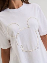 Bawełniana koszulka z aplikacją 3D Minnie Mouse - kremowy. Białe t-shirty damskie Sinsay, l, z aplikacjami, z bawełny, bez kołnierzyka. Za 29.99 zł.