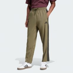 Spodnie Essentials 3-Stripes Stanford Open Hem. Brązowe spodnie sportowe męskie Adidas, z materiału. W wyprzedaży za 134.25 zł.