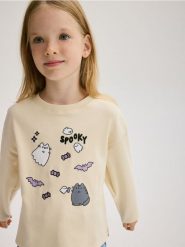 Koszulka z aplikacją Pusheen - kremowy. Białe koszulki dziewczęce Reserved, z aplikacjami, z bawełny, bez ramiączek. W wyprzedaży za 35.99 zł.