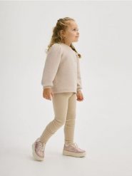 Bluza z kokardką - kremowy. Białe bluzy i bluzki niemowlęce Reserved, bez wzorów, z bawełny, bez ramiączek, bez kaptura. W wyprzedaży za 27.99 zł.