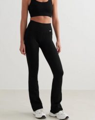 Damskie legginsy bezszwowe, prążkowane, wysoki stan, dzwony, długie, czarne. Czarne legginsy damskie Aim'n, m, bez wzorów, z elastanu. Za 301.00 zł.