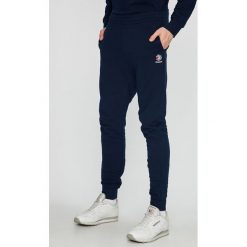 Reebok Classic - Spodnie. Niebieskie spodnie materiałowe męskie Reebok Classic, bez wzorów, z bawełny, casualowe. W wyprzedaży za 159.90 zł.