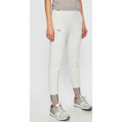 Under Armour - Spodnie. Białe spodnie sportowe damskie Under Armour, s, z materiału. W wyprzedaży za 279.90 zł.