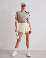 Damskie spodenki biegowe 2 w 1, szybkoschnące, oddychające Le Run cytrynowa biel. Żółte spodenki sportowe damskie Aim'n, bez wzorów, z elastanu. Za 297.00 zł.