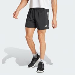 Szorty Own The Run. Niebieskie szorty męskie Adidas, z materiału, bez kołnierzyka. Za 179.00 zł.