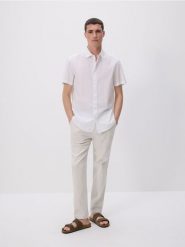 Spodnie chino slim - beżowy. Brązowe spodnie materiałowe męskie Reserved, bez wzorów, z bawełny. W wyprzedaży za 109.99 zł.