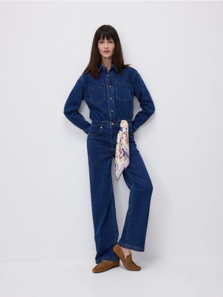 Jeansowy kombinezon - granatowy. Niebieskie kombinezony damskie Reserved, l, bez wzorów, z bawełny, bez kołnierzyka, bez ramiączek. Za 259.99 zł.