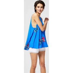 Top koszulowy z nadrukiem. Niebieskie topy damskie MOODO, l, bez wzorów, bez kołnierzyka. Za 24.99 zł.