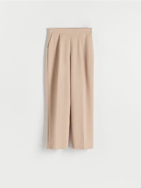 Spodnie z kantem - beżowy. Brązowe spodnie materiałowe damskie Reserved, bez wzorów, z tkaniny, z podwyższonym stanem. W wyprzedaży za 45.99 zł.