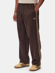 Adidas Spodnie dresowe adicolor Spacer KS7432 Brązowy ciemny Baggy Fit. Brązowe spodnie dresowe męskie Adidas, bez wzorów, z bawełny. Za 348.99 zł.