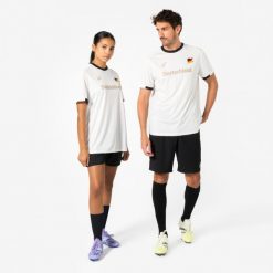 Koszulka piłkarska dla kibiców Niemcy 2026. Białe bluzki damskie KIPSTA, m, bez wzorów, z materiału, bez kołnierzyka. Za 44.99 zł.