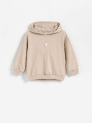 Bawełniana bluza z kapturem - kremowy. Białe bluzy i bluzki niemowlęce Reserved, bez wzorów, z bawełny, bez ramiączek, z kapturem. Za 49.99 zł.