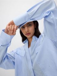 Krótka koszula z aplikacjami ze strasu - jasnoniebieski. Niebieskie koszule damskie Reserved, l, z aplikacjami, z bawełny, bez kołnierzyka, bez ramiączek. W wyprzedaży za 89.99 zł.