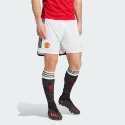 Spodenki do piłki nożnej męskie Manchester United 23/24 Home. Białe szorty męskie Adidas, bez wzorów, z materiału, sportowe. Za 184.30 zł.