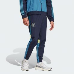 Spodnie dresowe Ajax Amsterdam Seasonal. Niebieskie spodnie dresowe męskie Adidas, bez wzorów, z dresówki. W wyprzedaży za 230.30 zł.