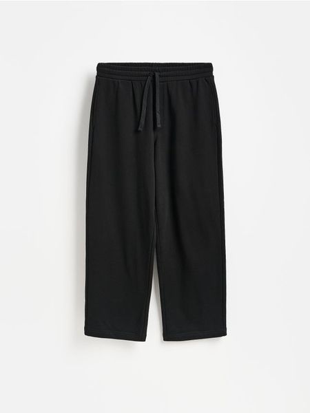 Spodnie baggy - czarny. Czarne spodnie materiałowe męskie Reserved, bez wzorów, z bawełny. Za 129.99 zł.