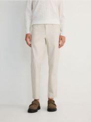 Bawełniane spodnie chino slim - jasnoszary. Szare spodnie materiałowe męskie Reserved, bez wzorów, z bawełny. W wyprzedaży za 49.99 zł.