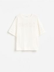 Bawełniany t-shirt z aplikacjami - złamana biel. Koszulki dziewczęce Reserved, z aplikacjami, z bawełny, bez ramiączek. Za 39.99 zł.