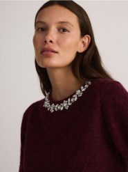 Sweter z biżuteryjną aplikacją - bordowy. Czerwone swetry klasyczne damskie Reserved, l, z dzianiny, bez kołnierzyka. W wyprzedaży za 119.99 zł.