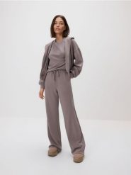 Spodnie long leg - brązowy. Brązowe spodnie materiałowe damskie Reserved, bez wzorów, z dzianiny. Za 119.99 zł.