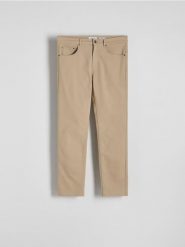 Bawełniane spodnie slim fit - beżowy. Brązowe spodnie materiałowe męskie Reserved, bez wzorów, z bawełny. W wyprzedaży za 89.99 zł.