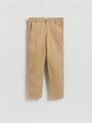 Bawełniane spodnie chino slim - beżowy. Brązowe spodnie materiałowe męskie Reserved, bez wzorów, z bawełny. Za 129.99 zł.