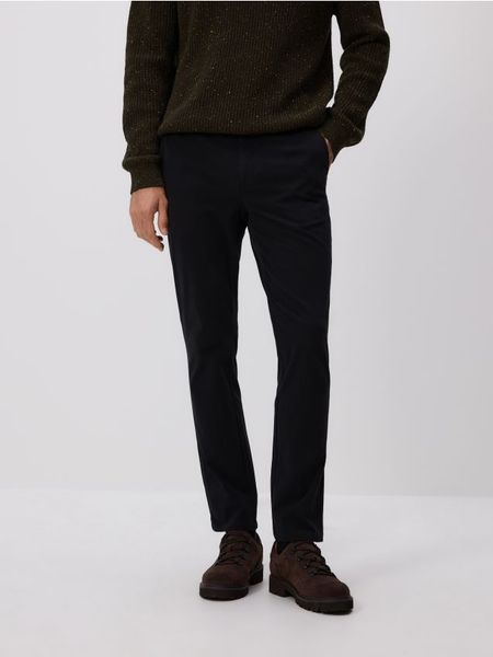 Spodnie chino slim fit - czarny. Czarne spodnie materiałowe męskie Reserved, bez wzorów, z bawełny. W wyprzedaży za 99.99 zł.