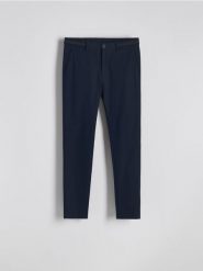 Spodnie chino slim fit - granatowy. Niebieskie spodnie materiałowe męskie Reserved, bez wzorów, z tkaniny. Za 159.99 zł.