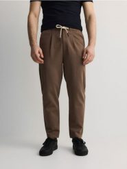 Spodnie chino regular z domieszką lyocellu - beżowy. Brązowe spodnie materiałowe męskie Reserved, bez wzorów, z dzianiny. W wyprzedaży za 89.99 zł.