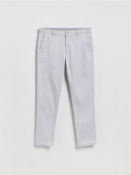 Spodnie chino slim - lawendowy. Fioletowe spodnie materiałowe męskie Reserved, bez wzorów, z bawełny. Za 159.99 zł.