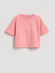 Luźny t-shirt z nadrukiem - brzoskwiniowy. Pomarańczowe koszulki dziewczęce Reserved, bez wzorów, z bawełny, bez ramiączek. Za 29.99 zł.