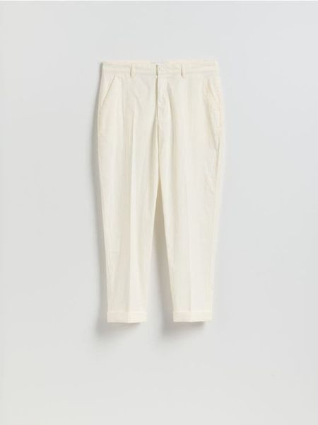 Spodnie carrot fit - złamana biel. Spodnie materiałowe męskie Reserved, bez wzorów, z bawełny. Za 149.99 zł.