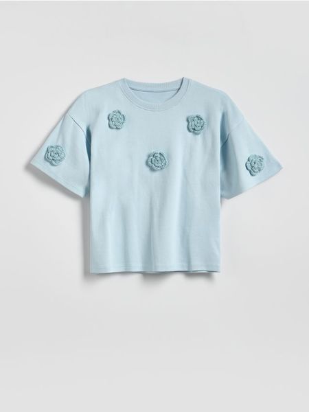 T-shirt z aplikacją - jasnoniebieski. Niebieskie koszulki dziewczęce Reserved, z aplikacjami, z bawełny, bez ramiączek. Za 39.99 zł.