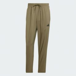 Spodnie Essentials 3-Stripes Stanford Open Hem. Brązowe spodnie sportowe męskie Adidas, z materiału. Za 179.00 zł.